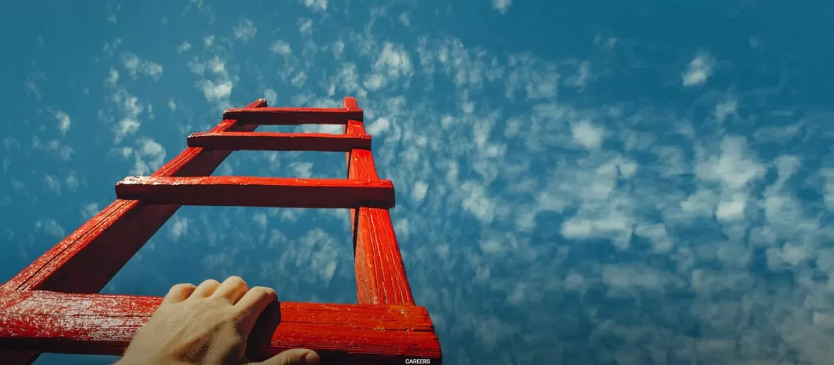 Stock image of a person climbing a ladder