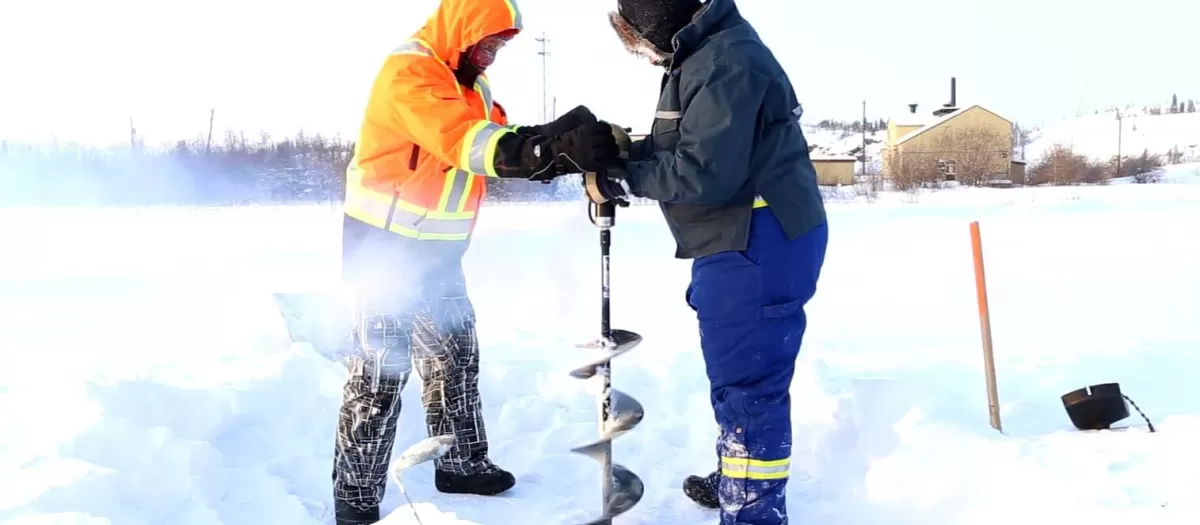 Two workers getting a sediment core sample